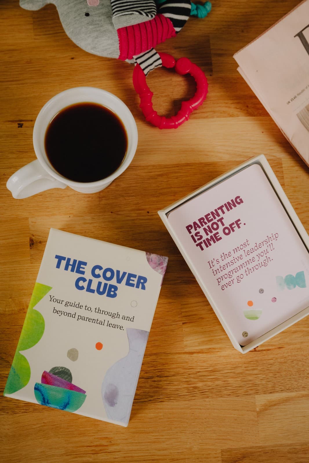 The Cover Club guide and card box beside a cup of coffee